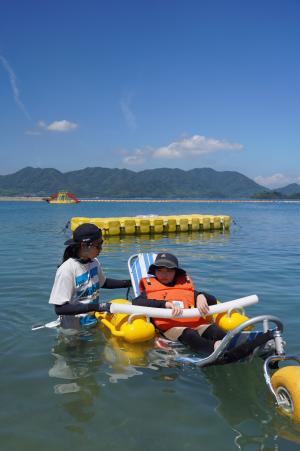 補助器具を使って海に浮いている写真