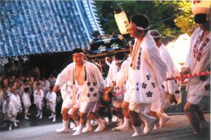 階段を上がる神輿と担ぎ手の写真