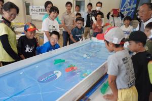 ボートが進むのを見守る子どもたちの写真