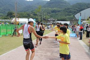 選手に水を手渡すボランティアの画像