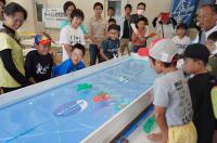 ボートが進むのを見守る子どもたちの写真