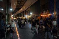 暗い商店街にぼんぼりと提灯の灯りがともっている写真